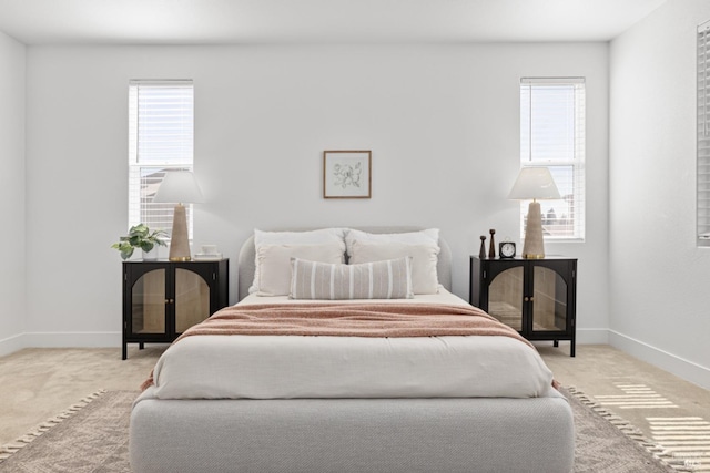 carpeted bedroom with multiple windows and baseboards