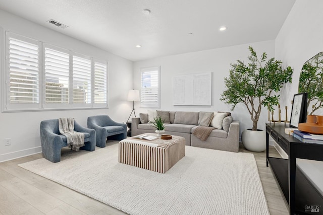 living room featuring light wood-type flooring, visible vents, baseboards, and recessed lighting