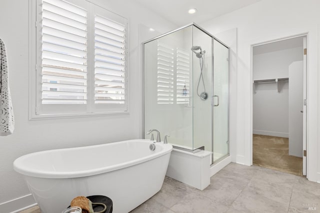 full bathroom featuring a stall shower, tile patterned flooring, and a freestanding bath