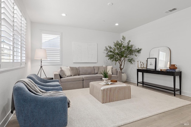 living area featuring recessed lighting, visible vents, baseboards, and wood finished floors