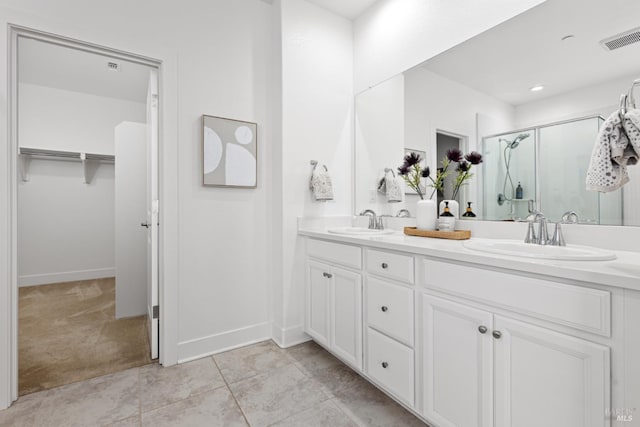 bathroom featuring double vanity, visible vents, a stall shower, and a sink