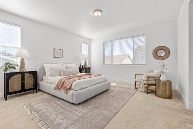 carpeted bedroom featuring multiple windows and baseboards