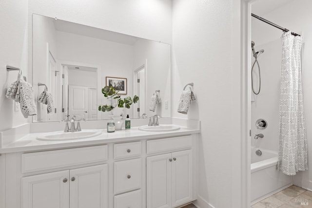 full bath with double vanity, a sink, shower / bath combo, and baseboards