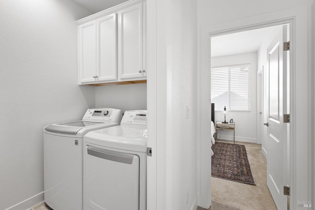 clothes washing area with light carpet, cabinet space, baseboards, and washer and dryer