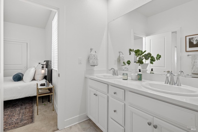 full bathroom featuring a sink, baseboards, and double vanity