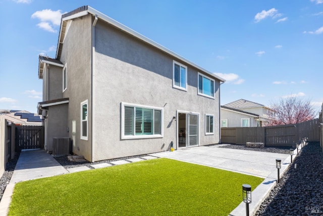 rear view of property with cooling unit, a patio area, a fenced backyard, and stucco siding