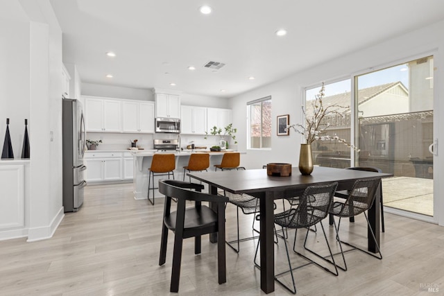 dining room with recessed lighting, visible vents, and light wood-type flooring