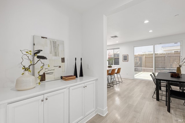 corridor with visible vents, baseboards, light wood-style flooring, and recessed lighting