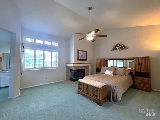 bedroom featuring baseboards, high vaulted ceiling, a tile fireplace, and light colored carpet