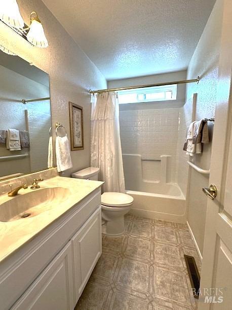 full bathroom featuring shower / tub combo, visible vents, toilet, a textured ceiling, and vanity