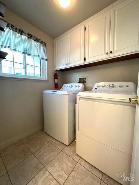 laundry room featuring cabinet space, independent washer and dryer, baseboards, and light tile patterned floors