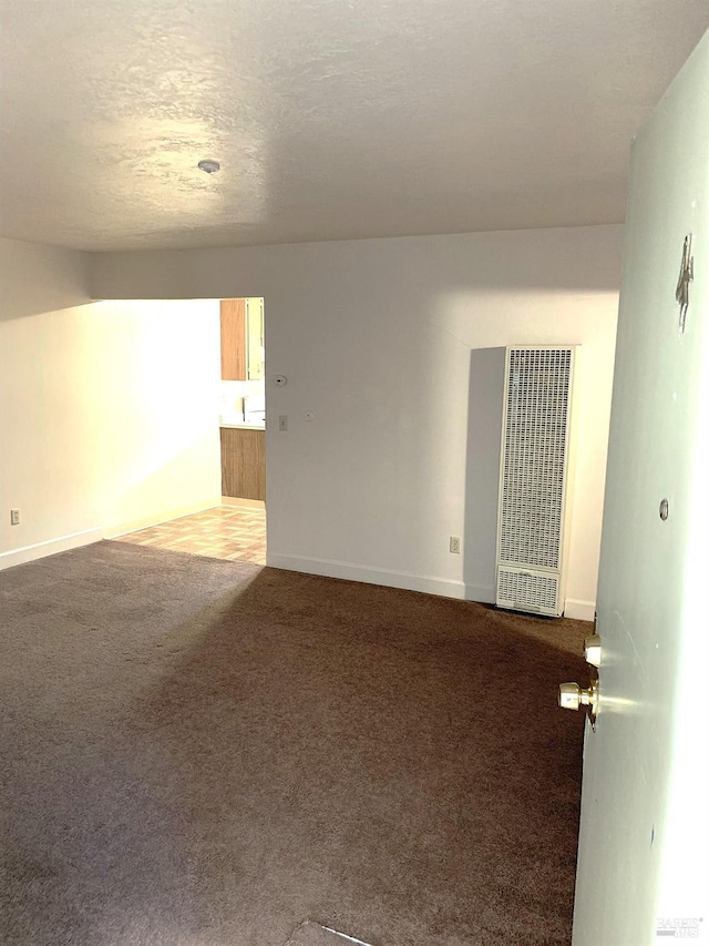 unfurnished room featuring carpet floors, baseboards, and a textured ceiling