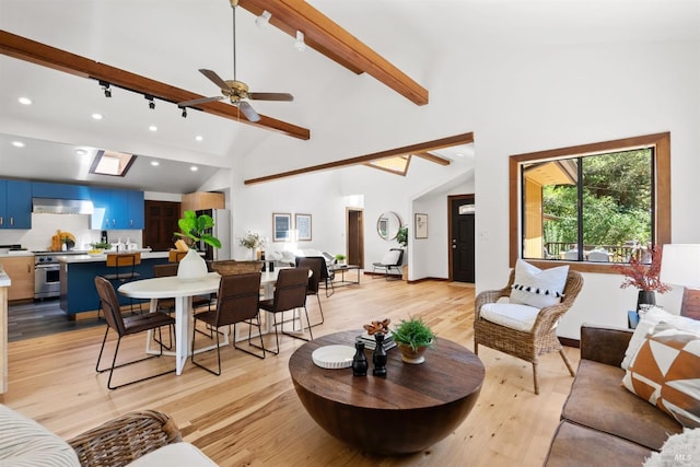 living area with ceiling fan, high vaulted ceiling, recessed lighting, beam ceiling, and light wood finished floors