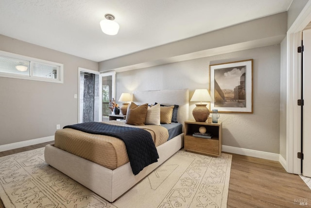 bedroom featuring light wood-style floors and baseboards