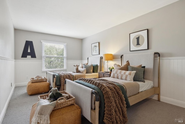 carpeted bedroom featuring wainscoting