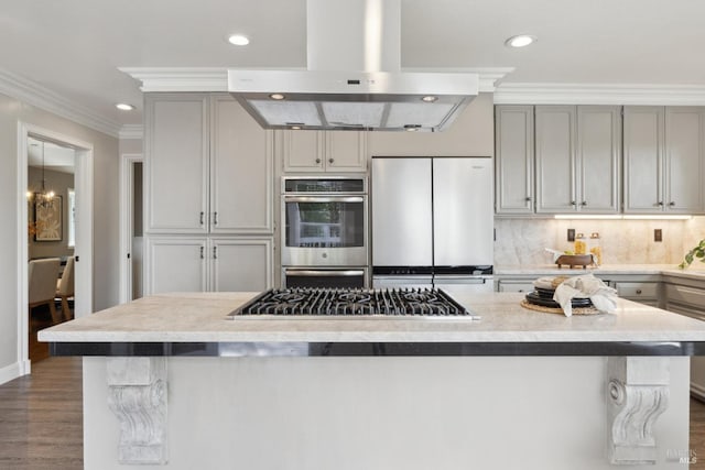 kitchen with island range hood, dark wood-style floors, appliances with stainless steel finishes, ornamental molding, and backsplash