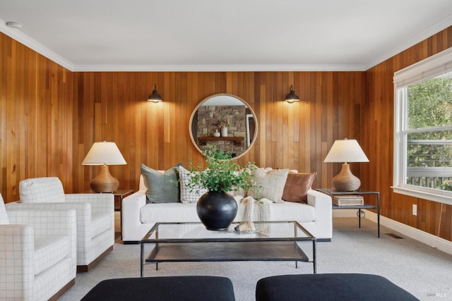 living room featuring carpet, crown molding, wooden walls, and baseboards