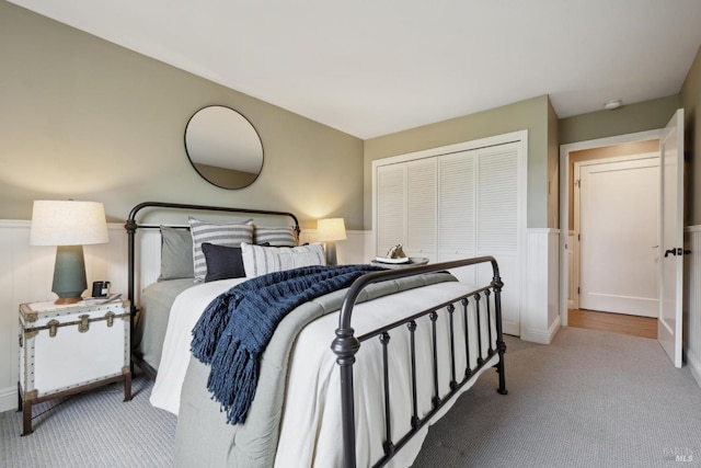 bedroom with carpet, a closet, and wainscoting