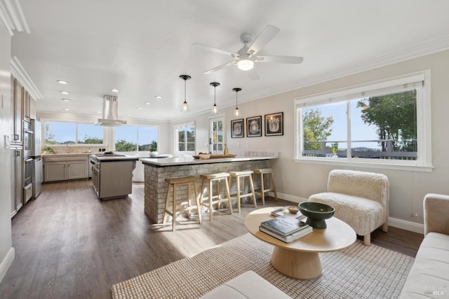 living room with recessed lighting, wood finished floors, a ceiling fan, baseboards, and crown molding