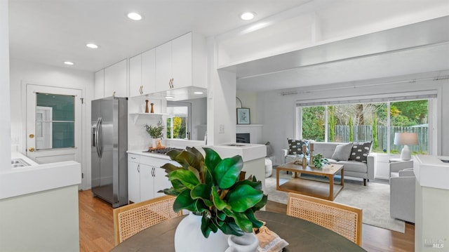 kitchen with light wood-style floors, white cabinetry, and stainless steel refrigerator with ice dispenser