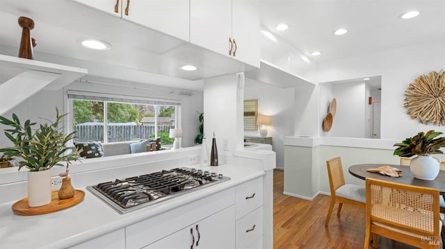 kitchen with recessed lighting, stainless steel gas cooktop, wood finished floors, white cabinetry, and light countertops