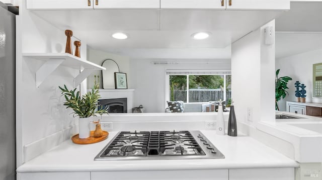 kitchen featuring recessed lighting, a fireplace, white cabinetry, light countertops, and stainless steel gas stovetop