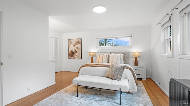 bedroom with light wood finished floors and baseboards