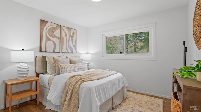 bedroom featuring wood finished floors and baseboards