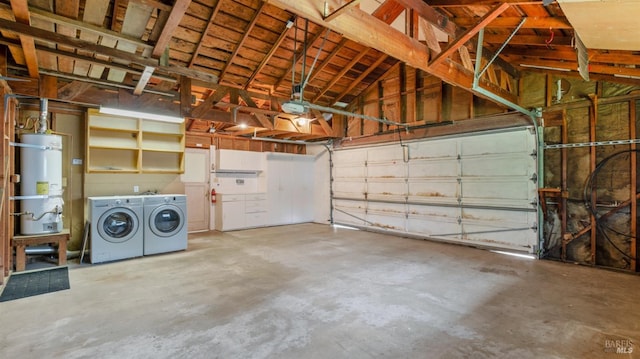 garage featuring water heater and washing machine and clothes dryer