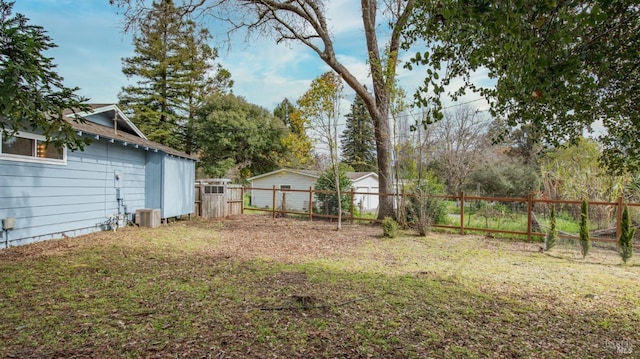 view of yard with a fenced backyard and central AC