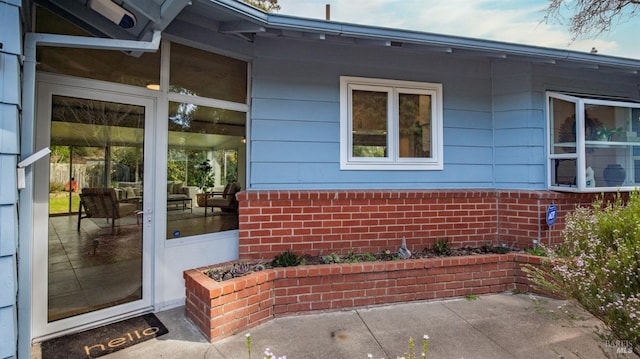 entrance to property featuring brick siding