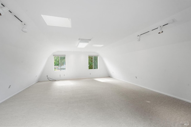 additional living space featuring carpet floors, vaulted ceiling, and baseboards