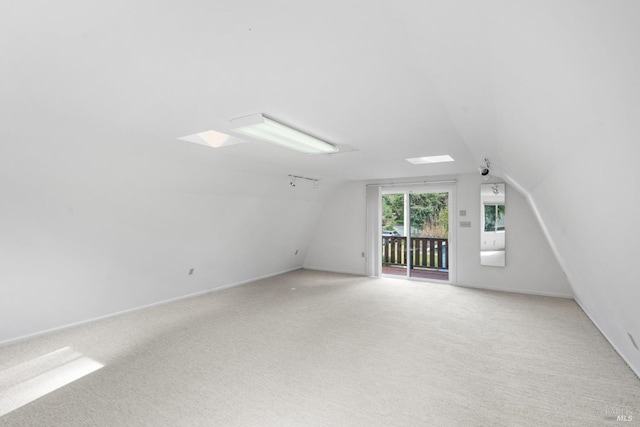 additional living space featuring lofted ceiling, light colored carpet, and baseboards