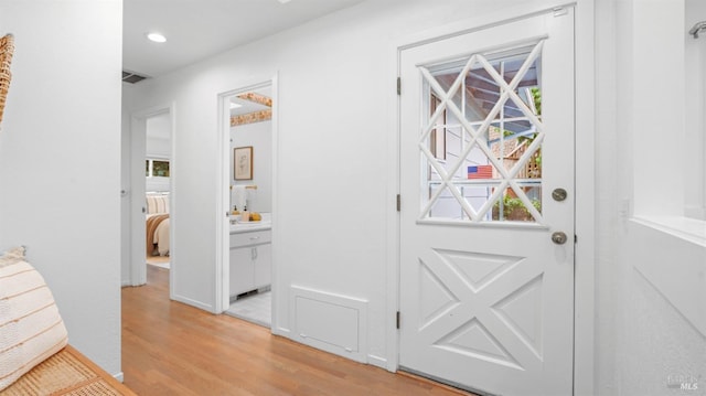 doorway with light wood-type flooring, visible vents, and recessed lighting