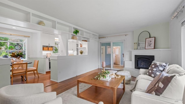 living area with light wood-type flooring and a brick fireplace