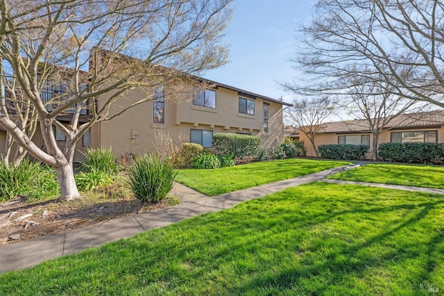 view of front of property featuring a front lawn and stucco siding