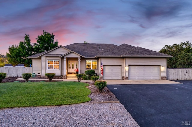 ranch-style house with aphalt driveway, fence, a garage, and a front yard