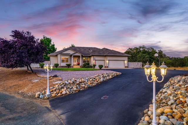 single story home with aphalt driveway and an attached garage