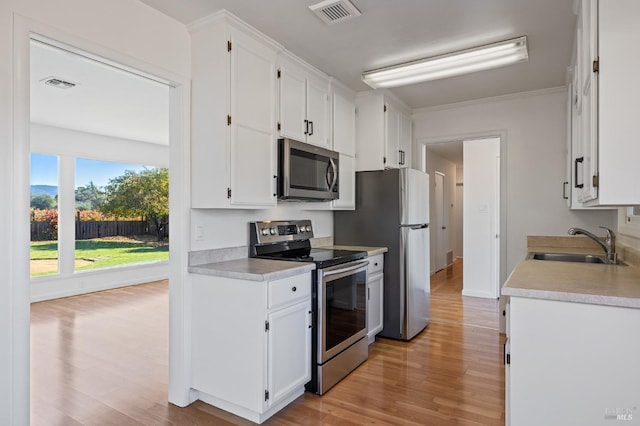 kitchen with visible vents, appliances with stainless steel finishes, white cabinets, and a sink