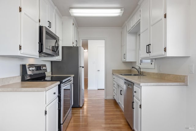 kitchen with white cabinetry, stainless steel appliances, and a sink