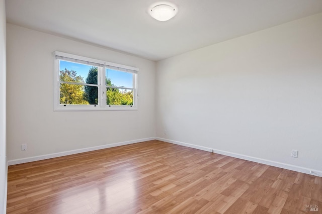 unfurnished room featuring light wood-style floors and baseboards