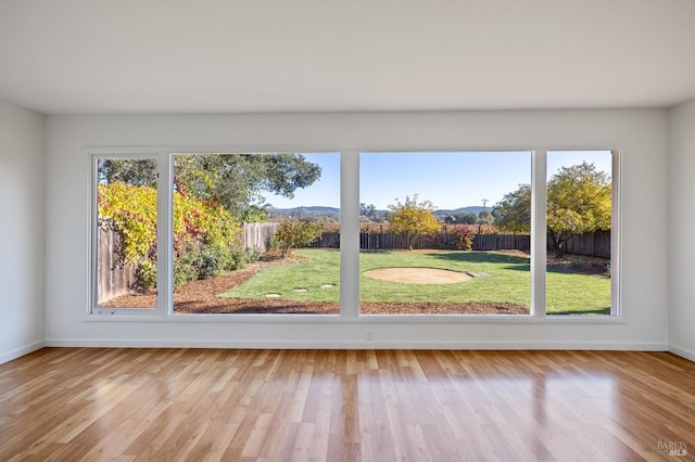 doorway to outside featuring light wood-type flooring, a healthy amount of sunlight, and baseboards