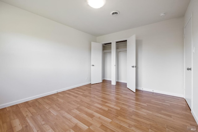 unfurnished bedroom featuring visible vents, light wood-style flooring, and baseboards