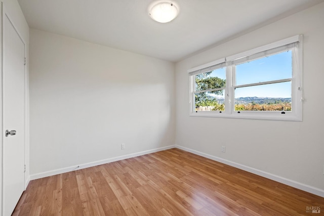 empty room featuring light wood-style flooring and baseboards