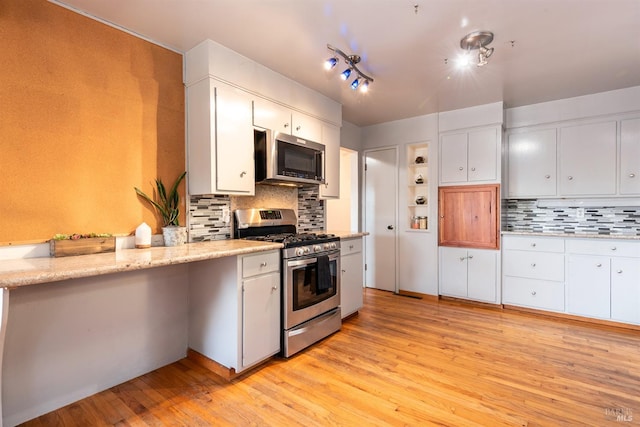 kitchen featuring appliances with stainless steel finishes, light wood-type flooring, and white cabinetry