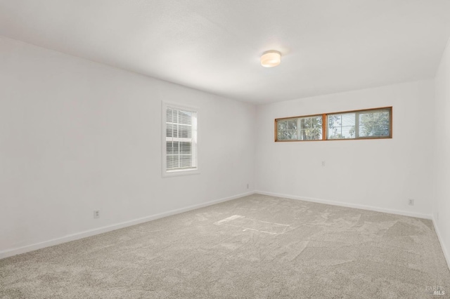 unfurnished room with carpet floors and baseboards