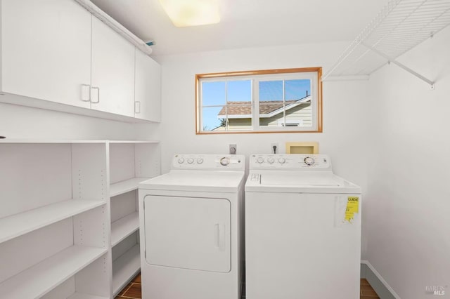 laundry room featuring cabinet space, baseboards, and washer and clothes dryer