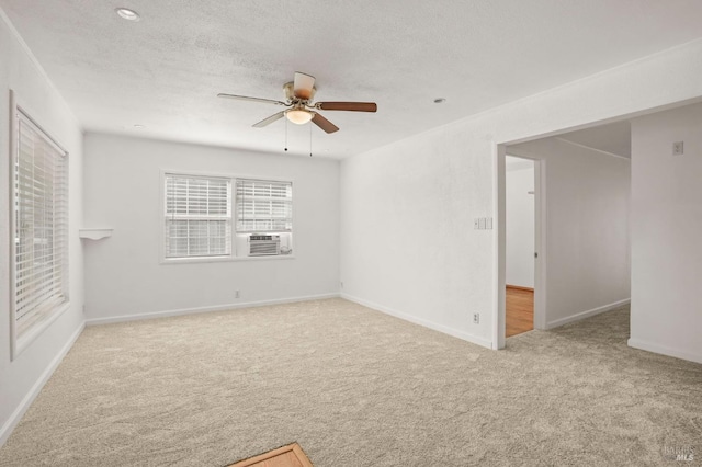 empty room featuring baseboards, a ceiling fan, cooling unit, a textured ceiling, and carpet floors