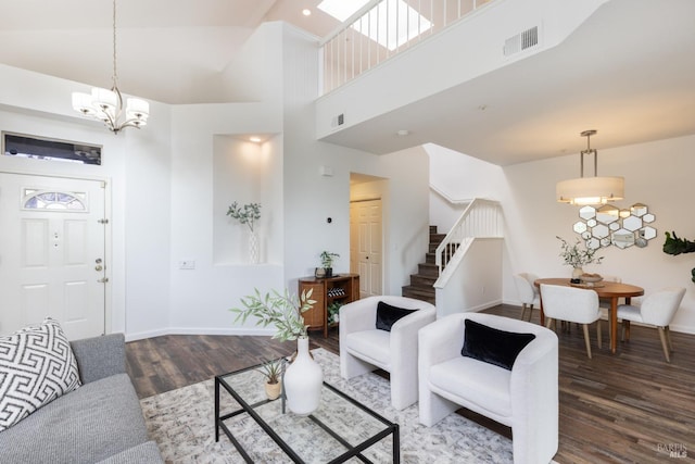 living room with stairs, wood finished floors, visible vents, and a chandelier