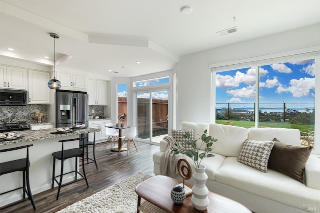 living area featuring recessed lighting, visible vents, and dark wood finished floors